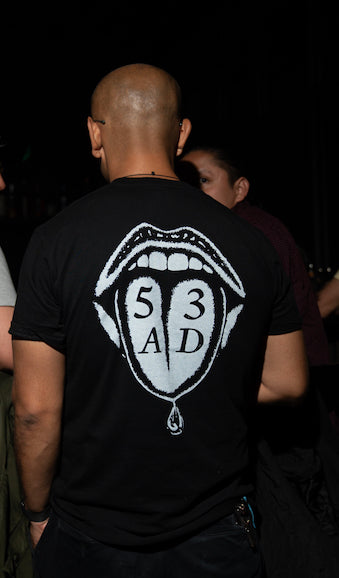 Empirical 53AD Flavor Tee worn at the bar, back graphic visible