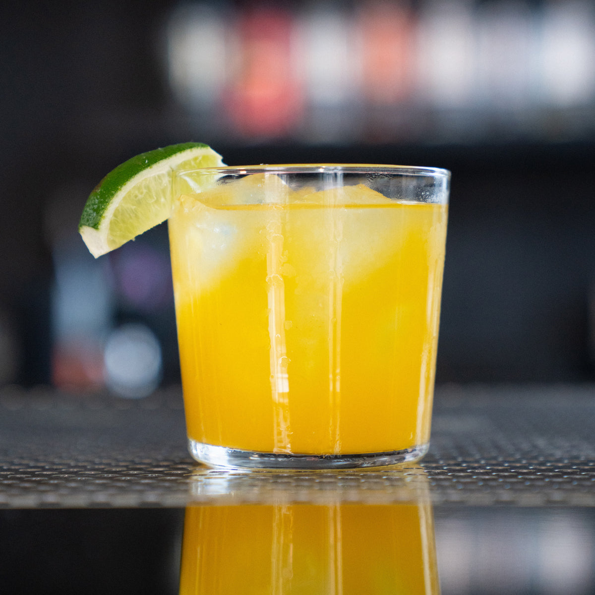 Cilantro & Mango cocktail in a rocks glass with lime