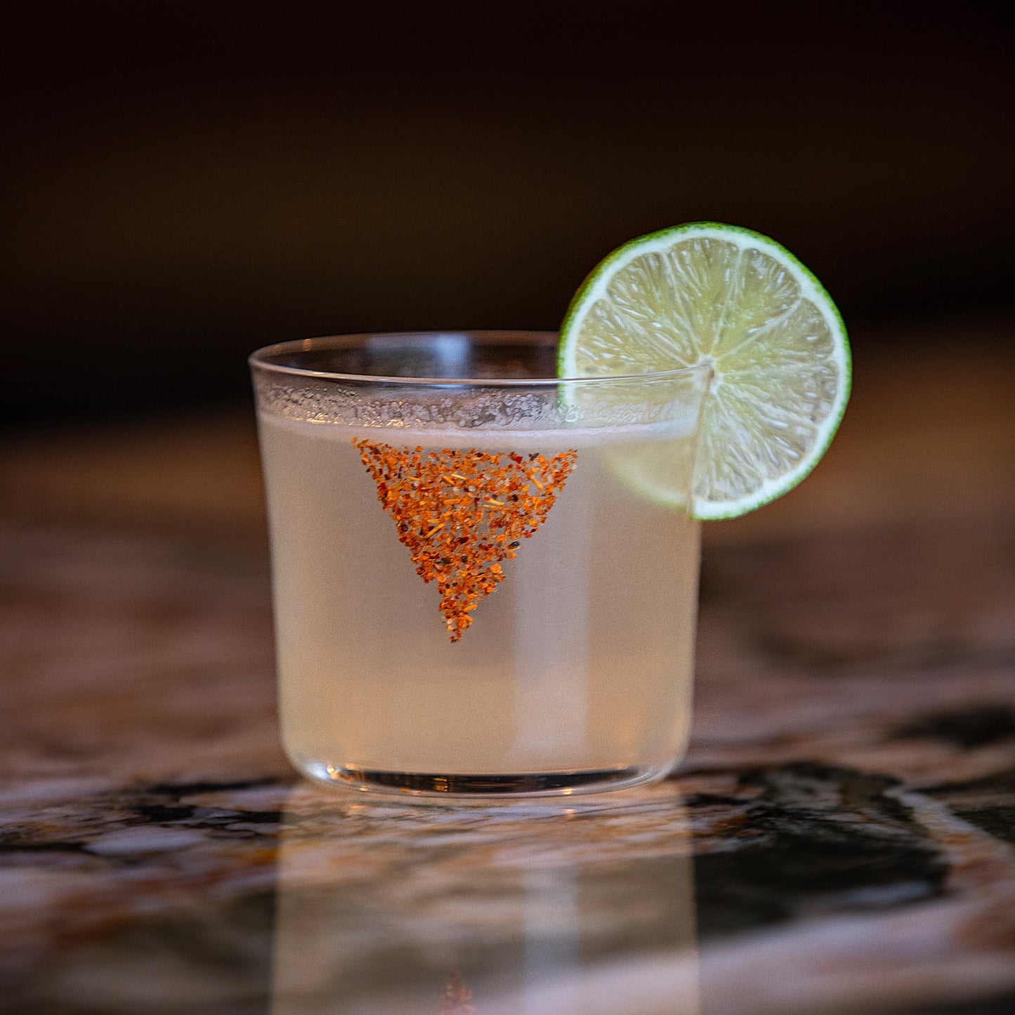 Empirical x Doritos cocktail with a chili-salt rim and lime wheel garnish