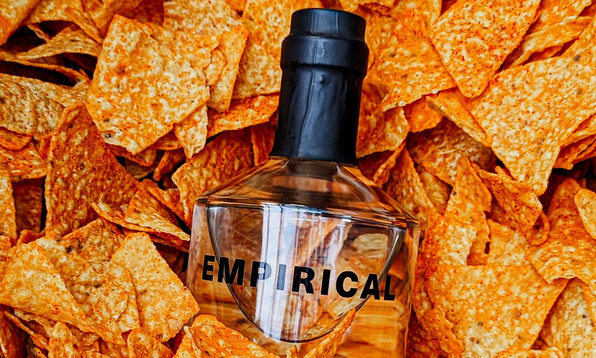 Empirical x Doritos bottle nested in a bed of orange Doritos chips