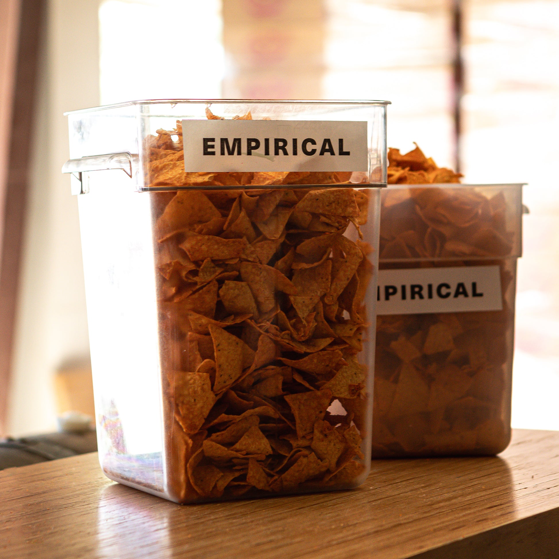 Containers of crushed Doritos chips labeled EMPIRICAL, ready for infusion