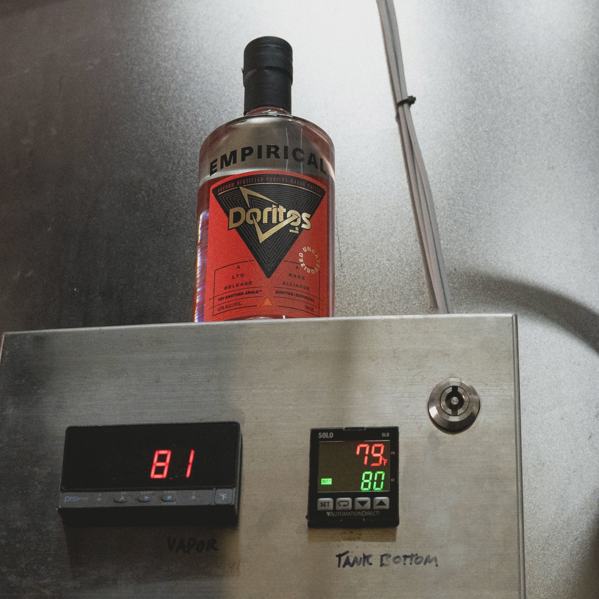 Empirical x Doritos bottle on top of a stainless tank with temperature controllers reading 81 / 80