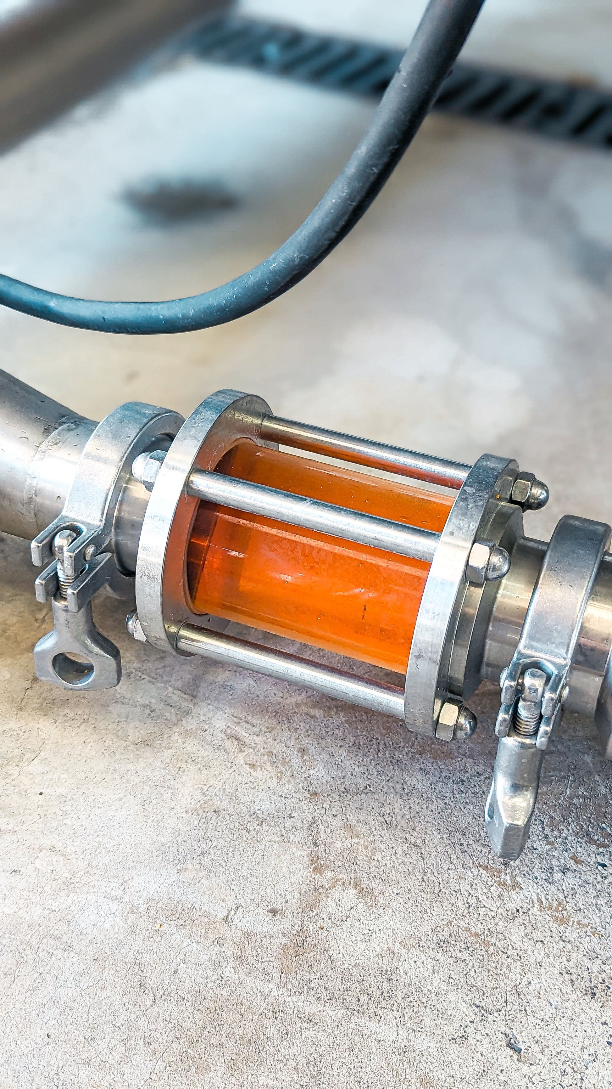Glowing Doritos-infused spirit visible in a stainless distillation rig — Red Bag production still