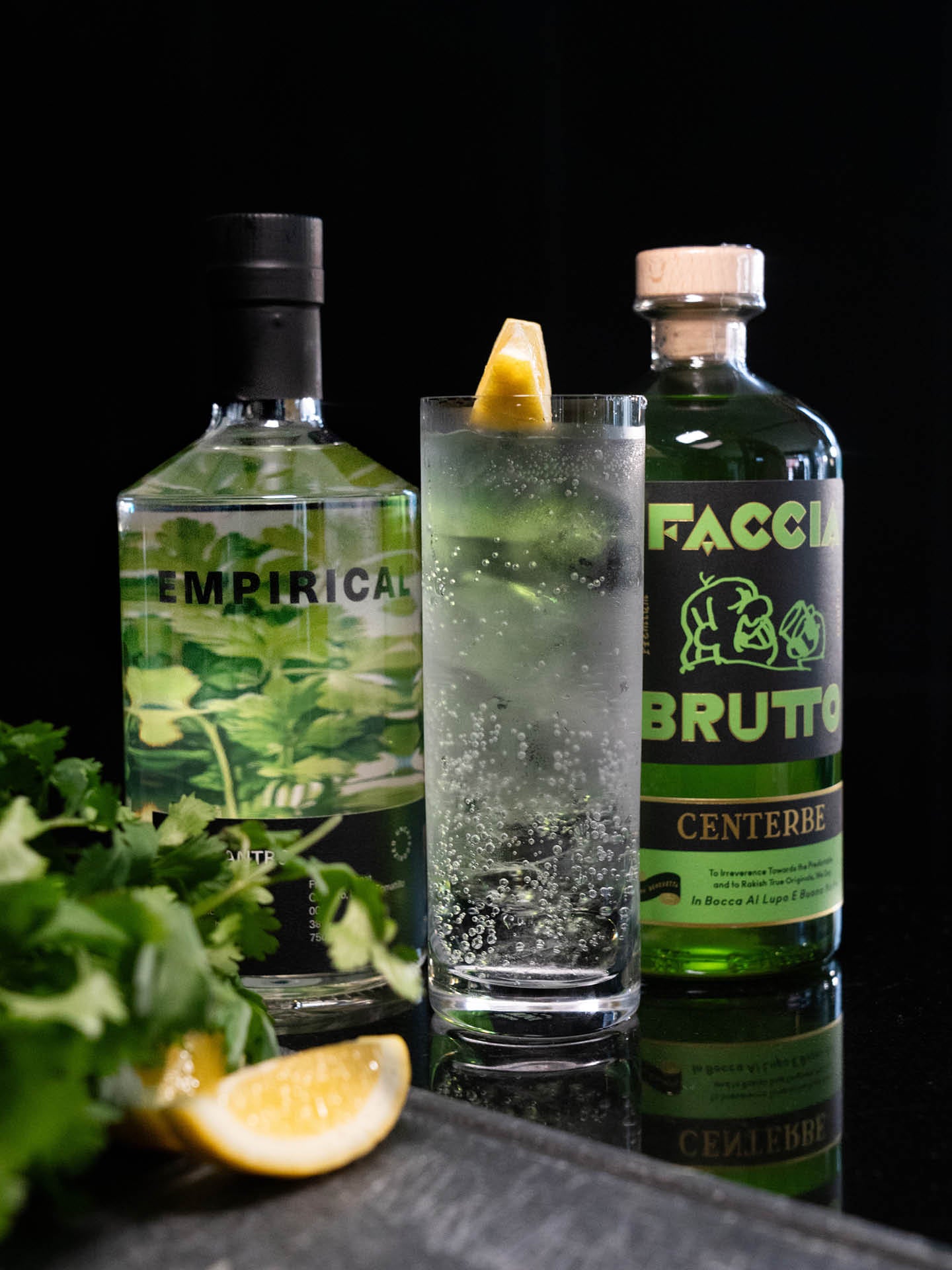 Empirical Cilantro and Faccia Brutto Centerbe bottles flanking a highball with lemon