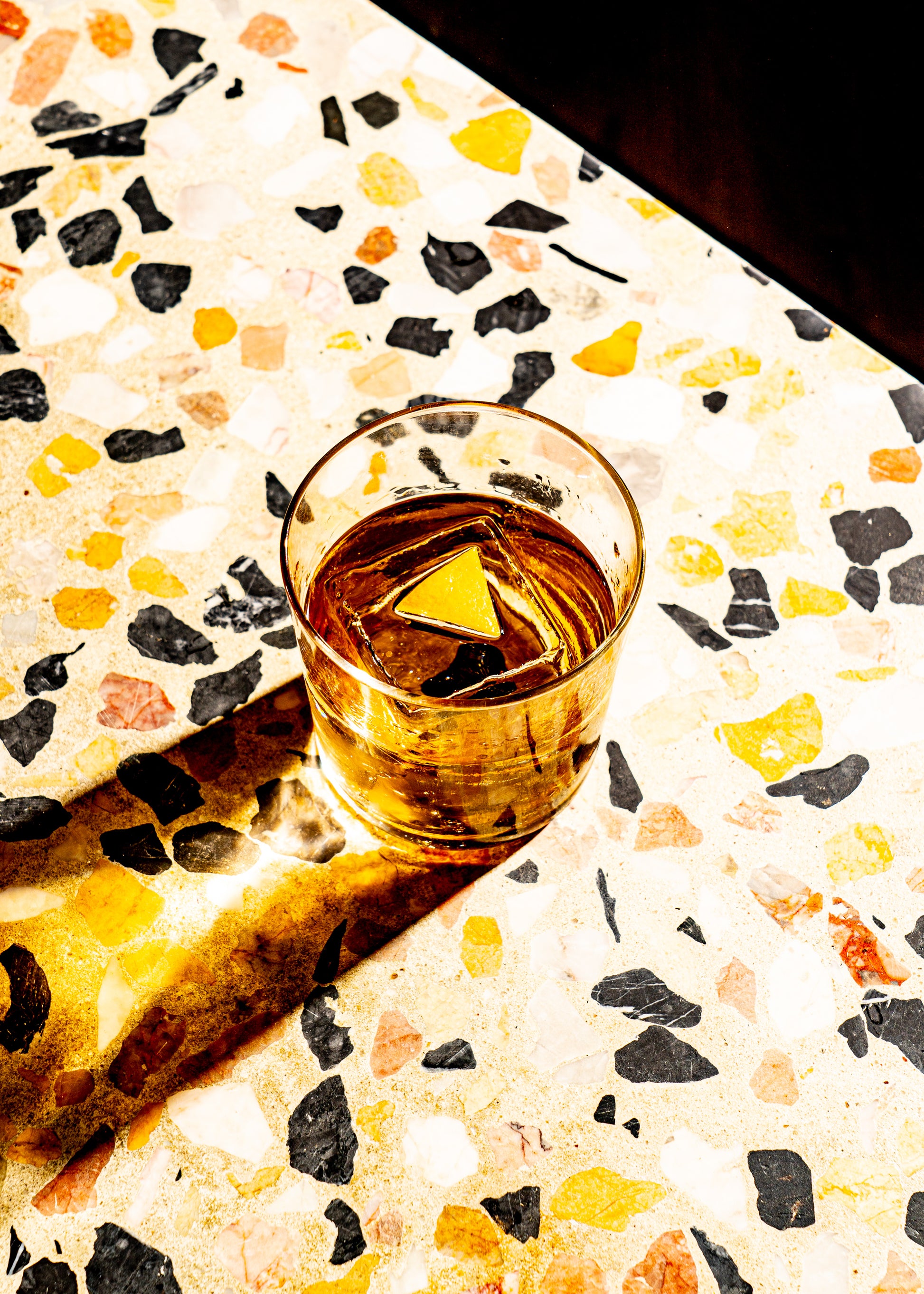 Red Bag Old Fashioned in a rocks glass on a terrazzo bar