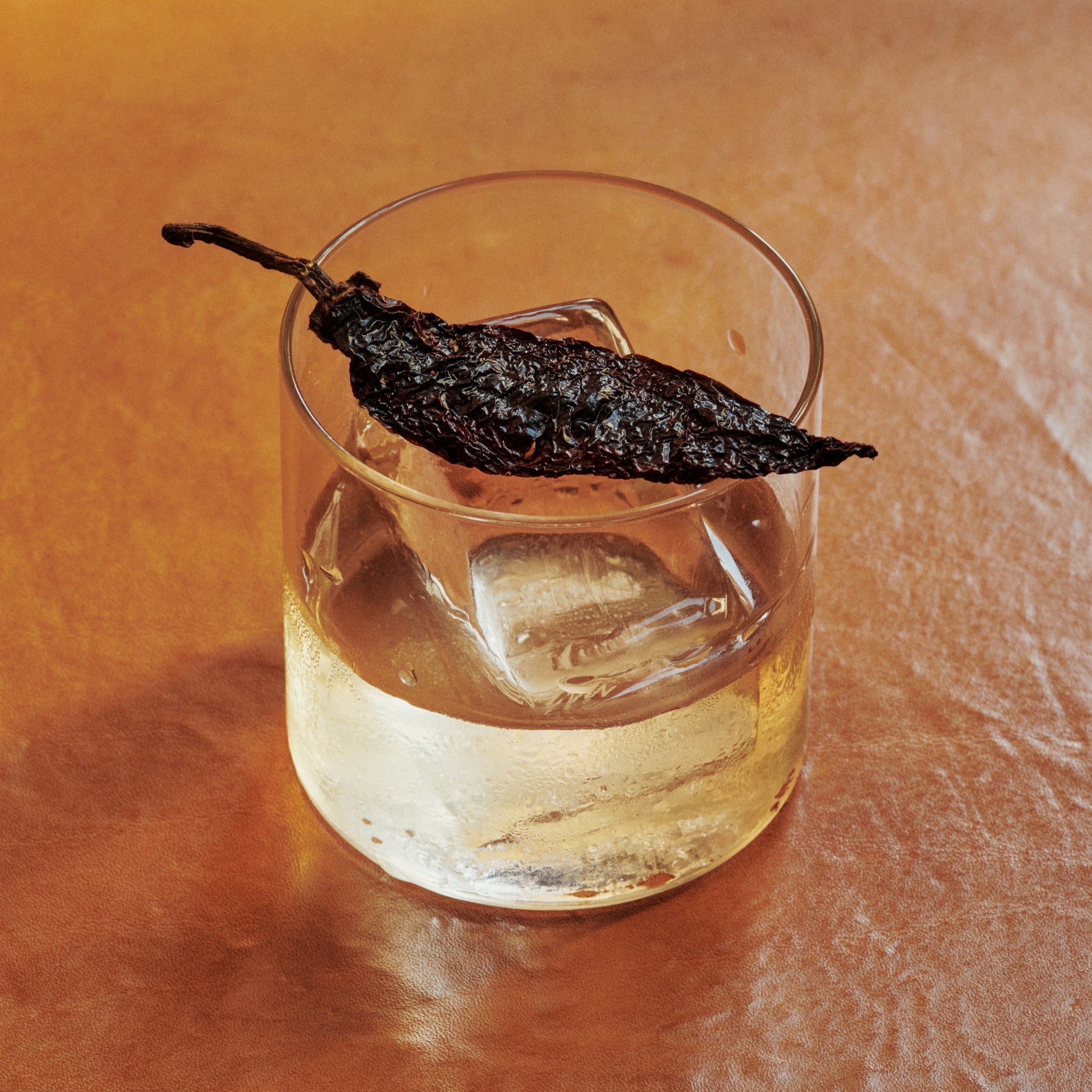 Ayuuk old fashioned cocktail garnished with a charred pasilla mixe chili