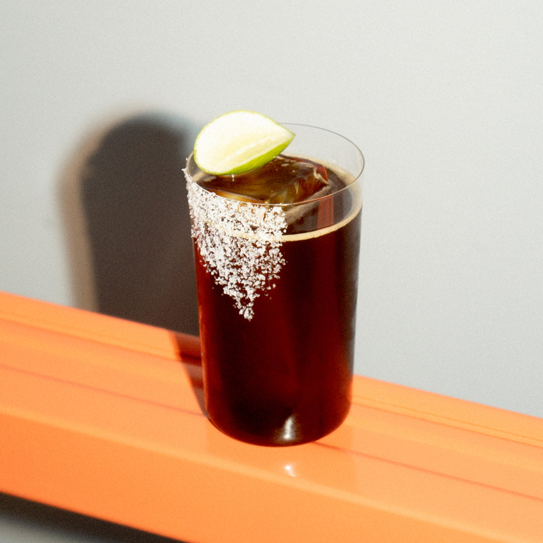 Soka & Cola in a tall glass with sugar rim and lime wedge