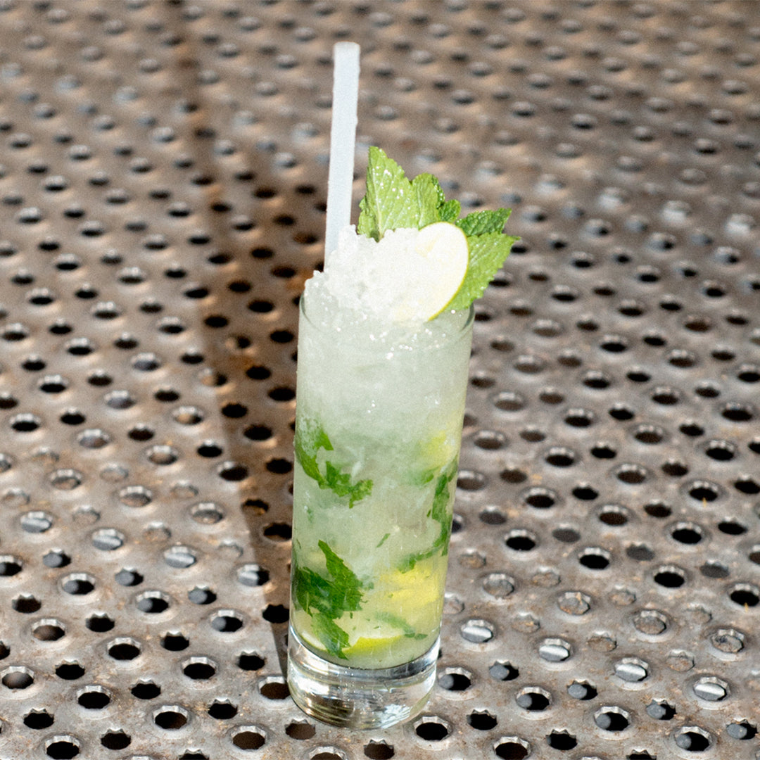 Soka mojito with crushed ice, mint, and lime on a perforated steel surface