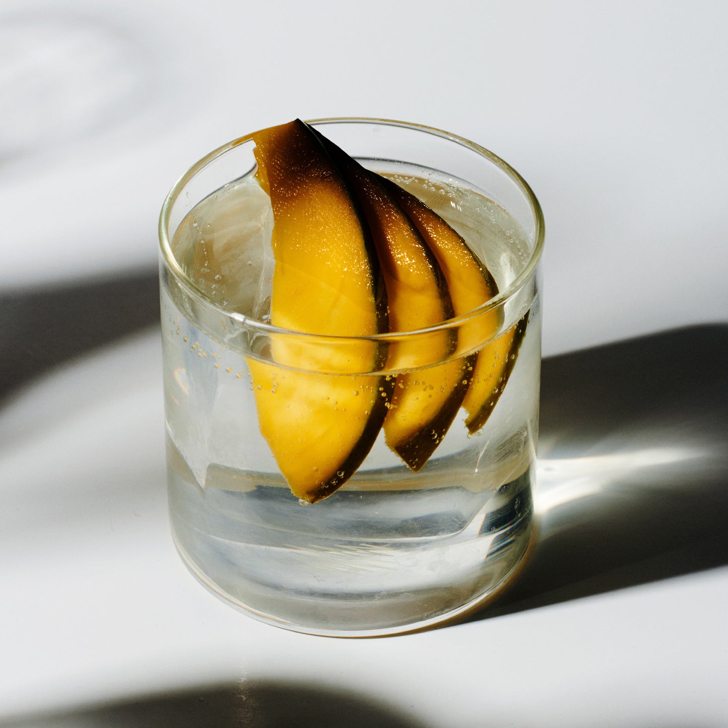 Soka cocktail in a rocks glass with charred mango slices